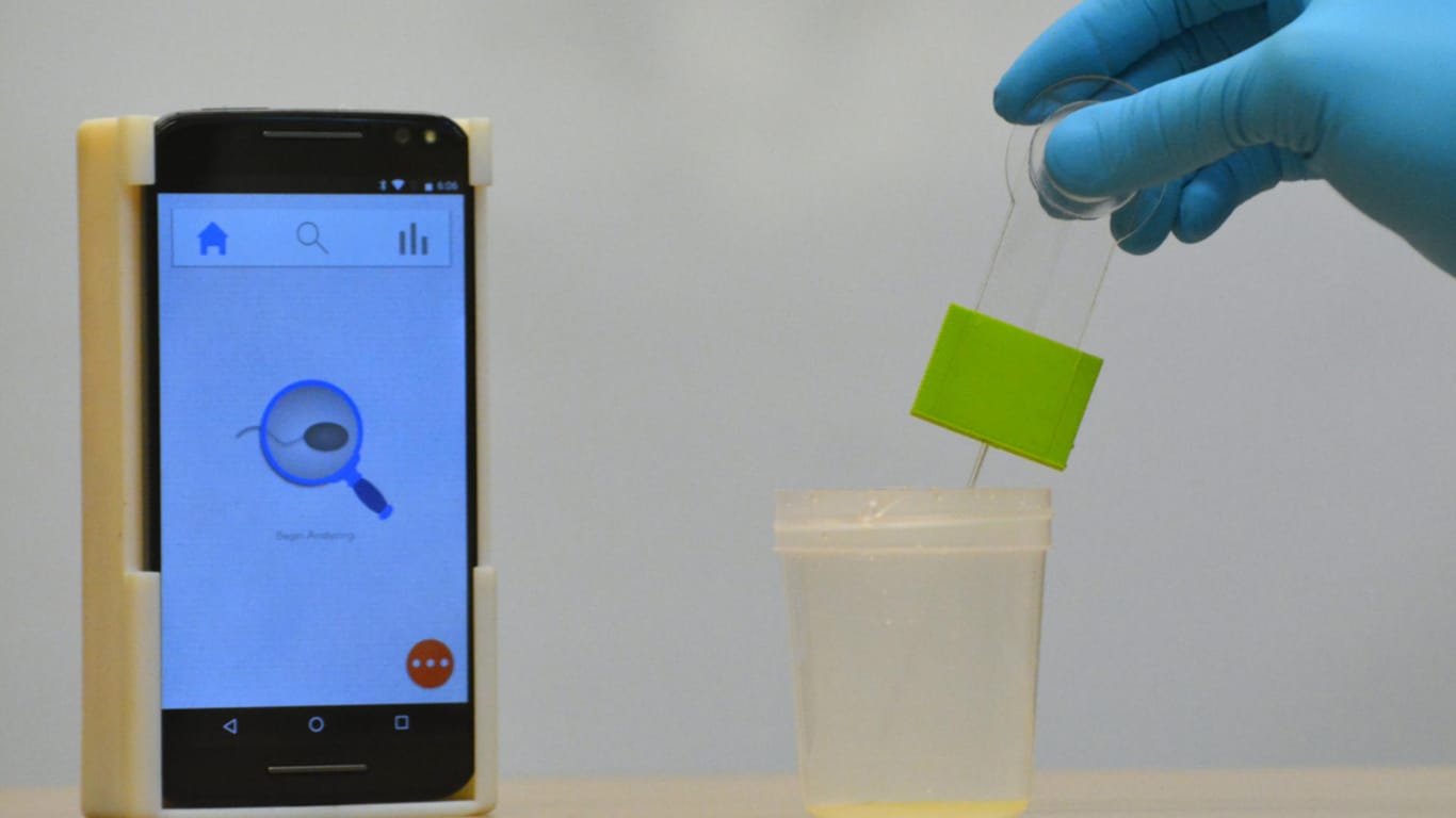 Das Fruchtbarkeits-Testsystem besteht aus einem optischen Zubehörteil, auf dem das Smartphone befestigt wird (l) und einer Spermaprobe (r).