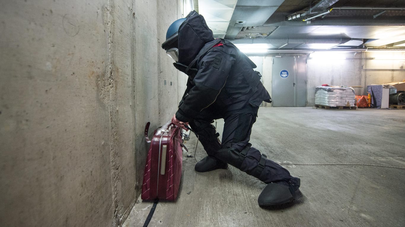 Ein verdächtiger Koffer wird von einem Bombenentschärfer untersucht.