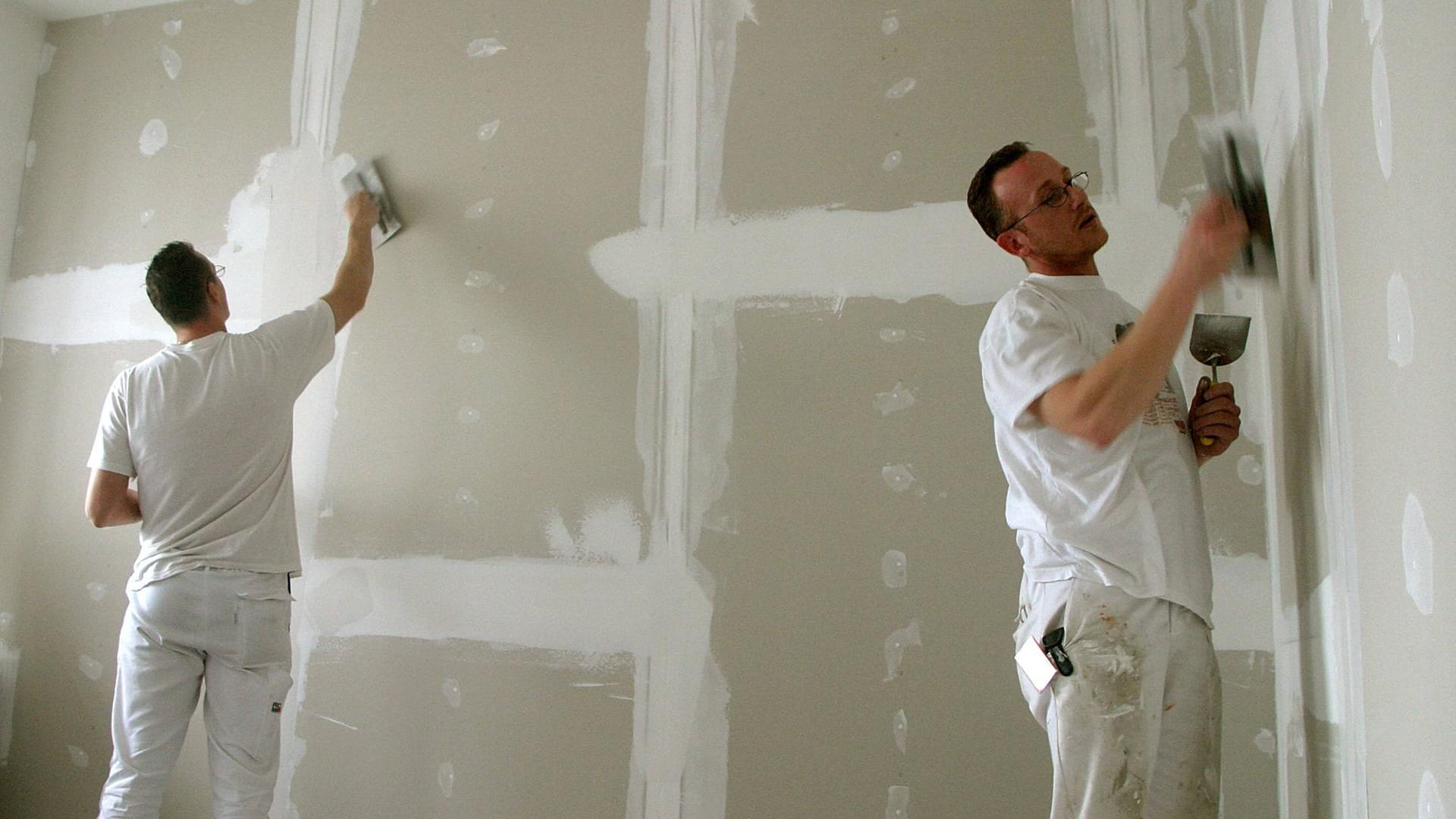 Maler verspachtelt eine Gipskartonwand: Mit etwas Geschick können Sie aus einem großen Raum zwei Zimmer machen.