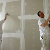 Maler verspachtelt eine Gipskartonwand: Mit etwas Geschick können Sie aus einem großen Raum zwei Zimmer machen.