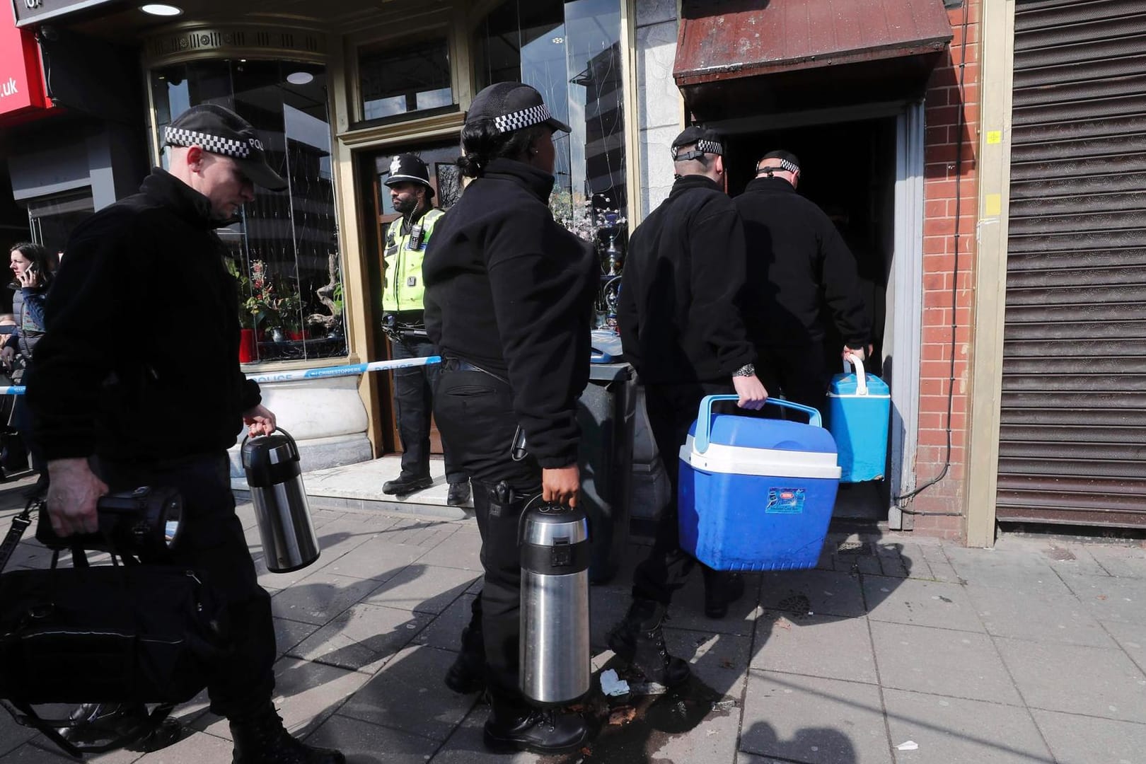 Polizisten kehren mit Equipment in eine Wohnung in Birmingham zurück, die nach dem Anschlag in London durchsucht wurde.