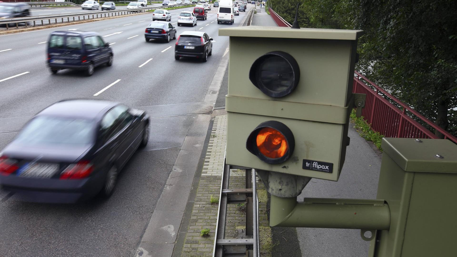 Am Straßenrand lauern die Blitzer und machen mit einer Verkehrskamera Fotos von Verkehrssündern.