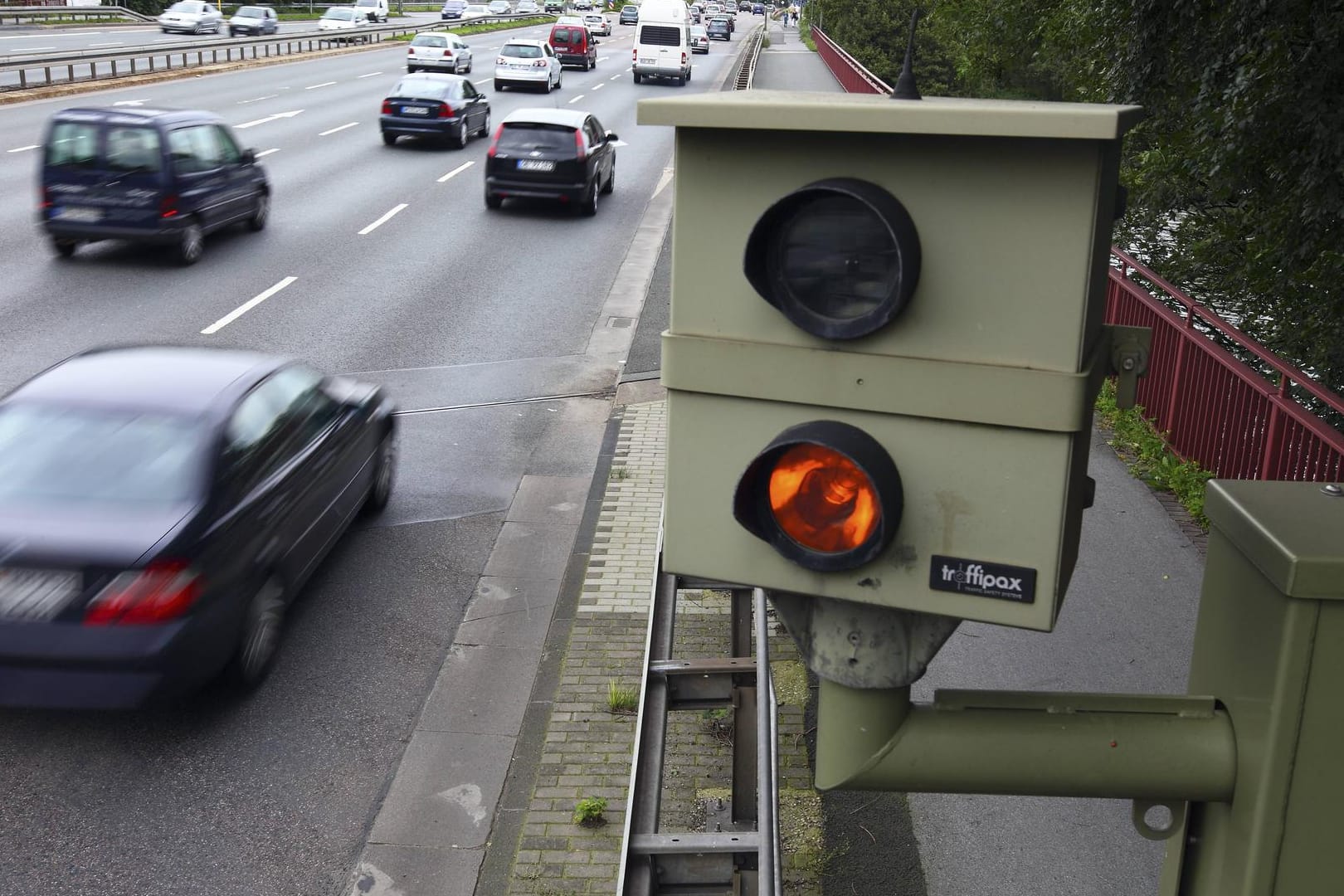 Am Straßenrand lauern die Blitzer und machen mit einer Verkehrskamera Fotos von Verkehrssündern.