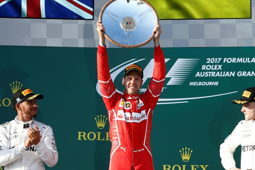 Sebastian Vettel feiert seinen Triumph. Lewis Hamilton (l.) klatscht fair Beifall, während sich Valtteri Bottas auf finnische Art freut.