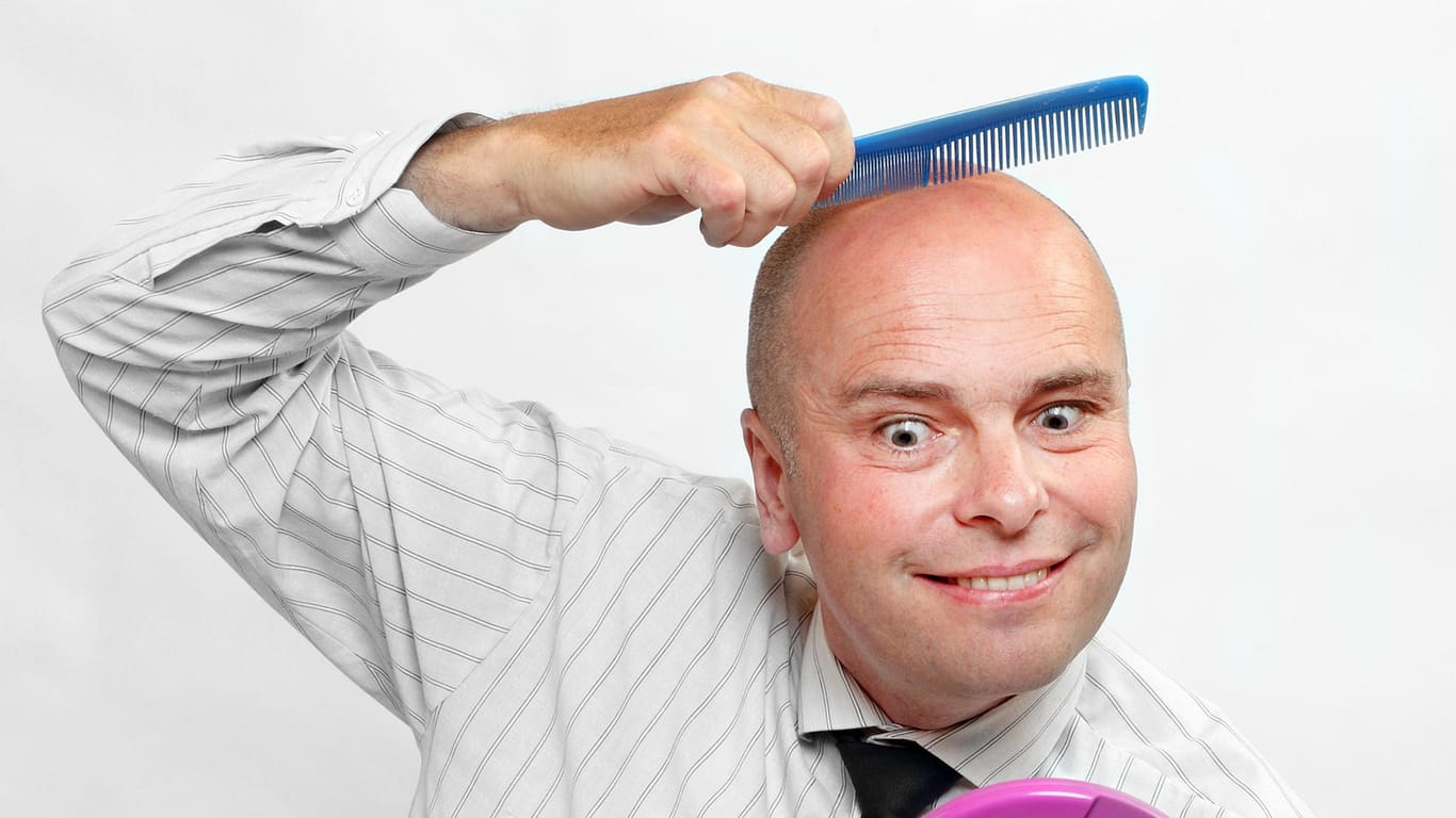 Ein Mann mit Glatze kämmt sich die Haare (Symbolbild)