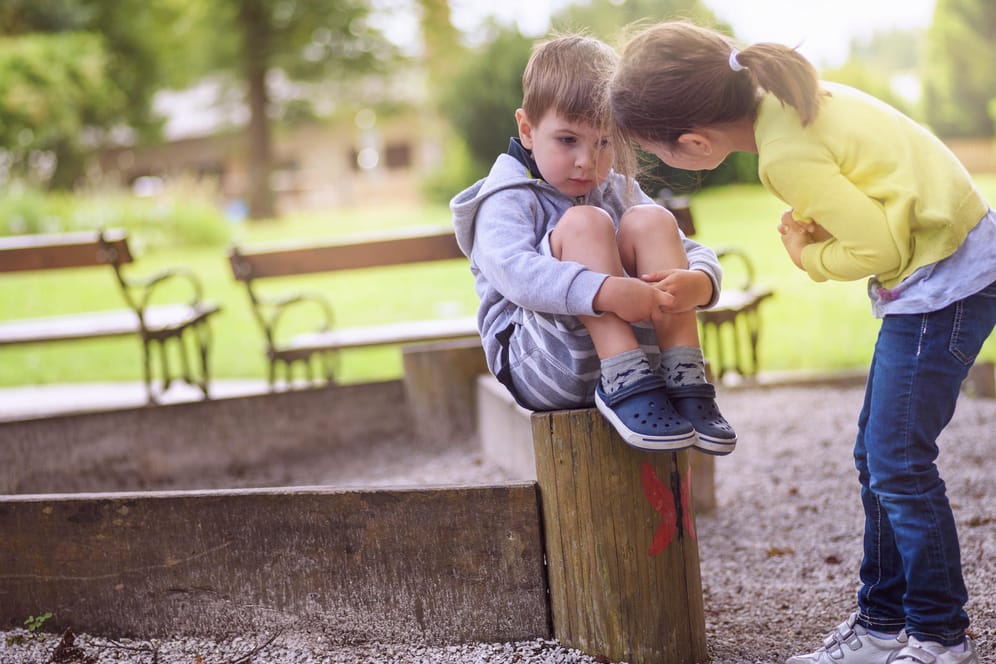Ein Mädchen spricht mit seinem jüngeren Bruder: Kinder können die Gedanken anderer erst mit etwa vier Jahren nachempfinden.