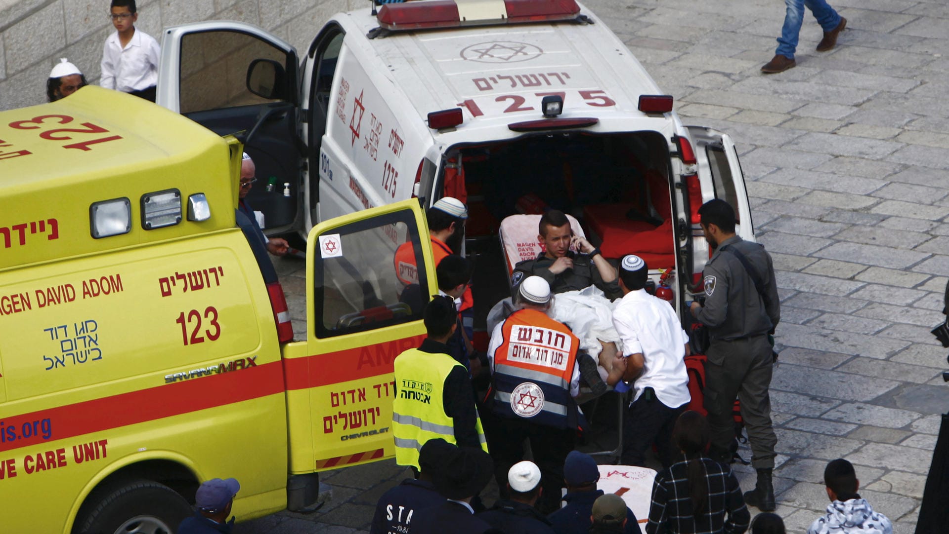 Ein verletzter Grenzpolizist wird in einen Krankenwagen geschoben.