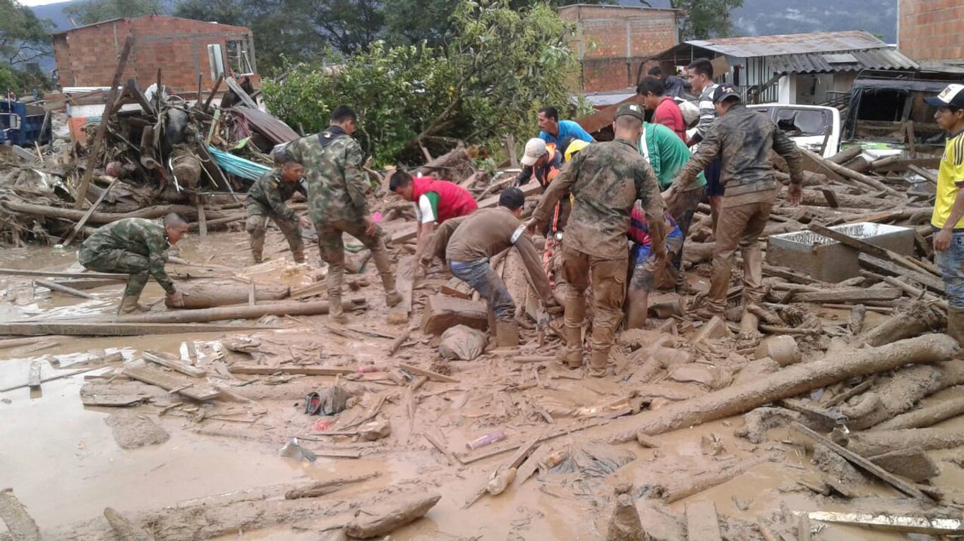 Soldaten und freiwillige Helfer suchen in den Trümmern nach Opfern.
