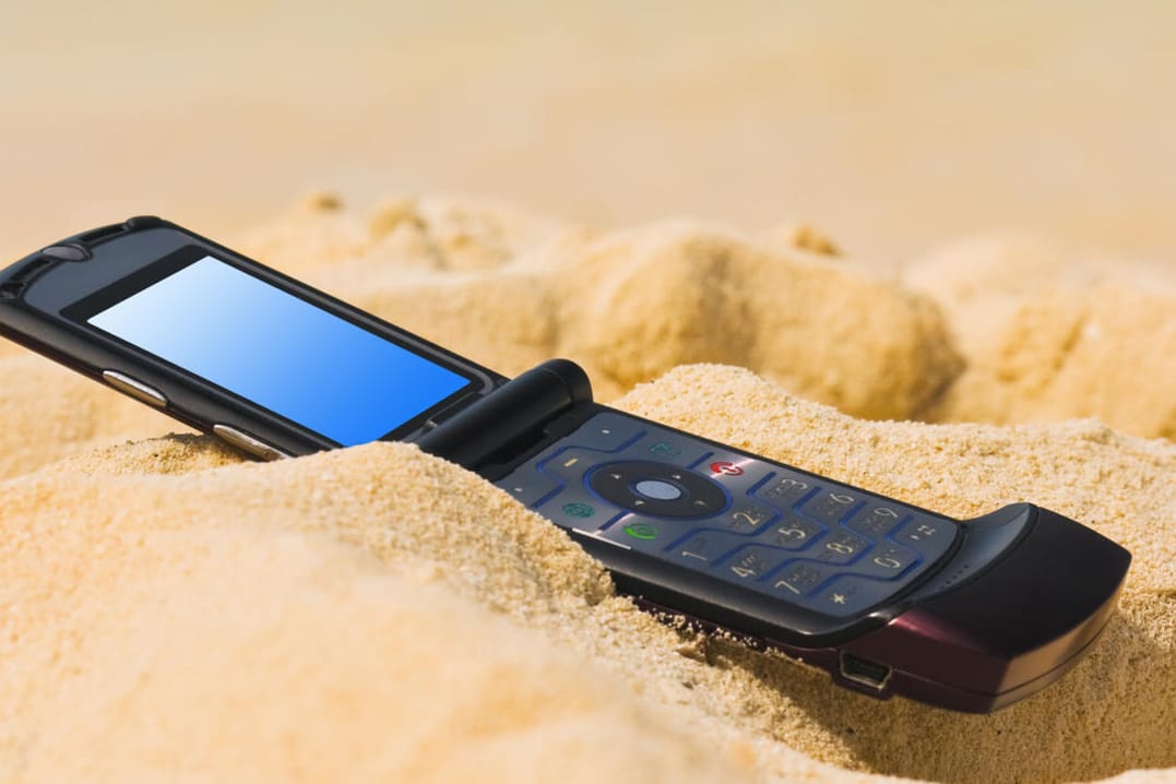 Handy am Strand. Ab Mitte Juni müssen Urlauber im Ausland keine Roaming-Gebühren mehr zahlen.