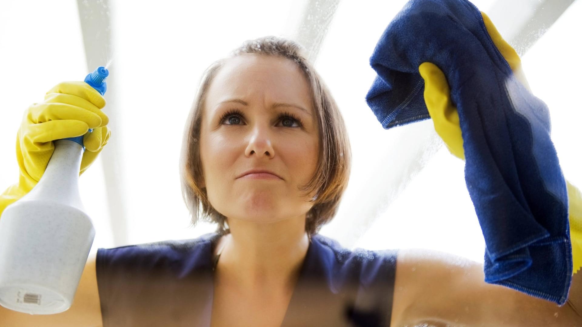 Junge Putzfrau beim Fensterputzen