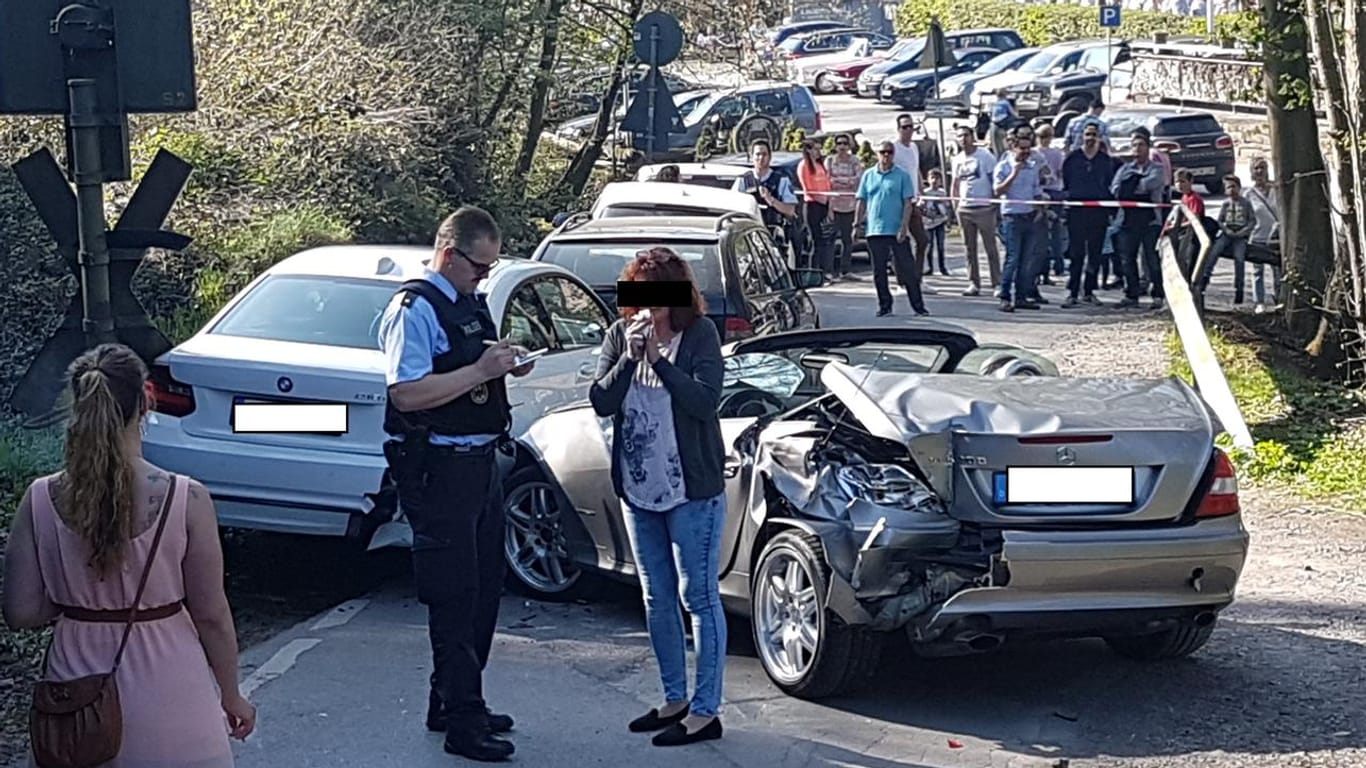 Ein Polizist nimmt den Unfall auf, das übel zugerichtete Auto steht im Hintergrund.