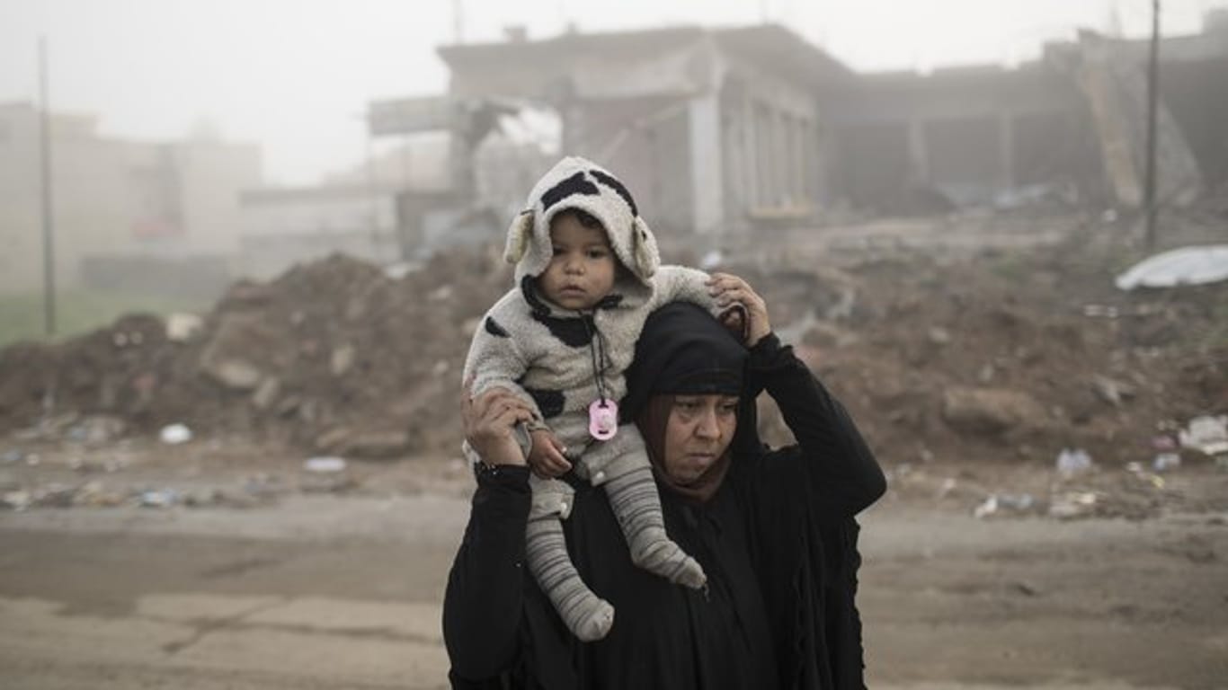 Frau und Kind fliehen vor den Gefechten zwischen der irakischen Armee und dem IS in Mossul.