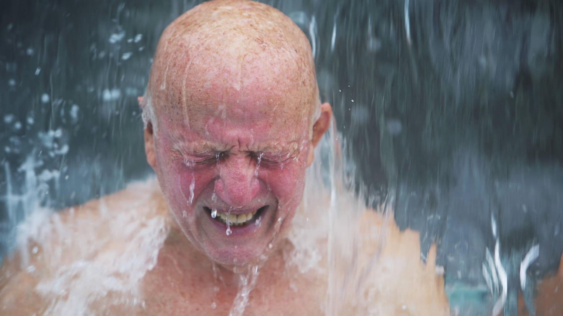 Mann verzerrt sein Gesicht unter der Dusche