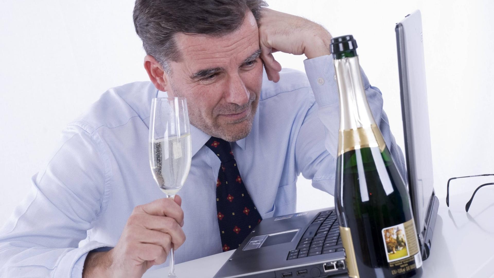 Geschäftsmann mit Sekt bei der Arbeit Geschäftsmann mit Sekt bei der Arbeit