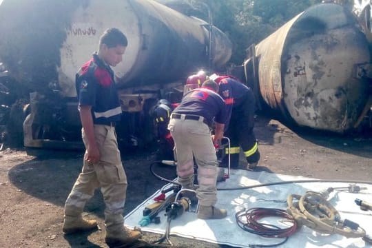 Feuerwehrmänner überprüfen in Morelia (Mexiko) die Überreste eines LKW.