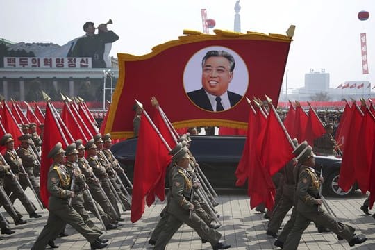 Nordkoreanische Soldaten tragen Flaggen und ein Foto von Kim Il Sung bei der Militärparade in Pjöngjang.