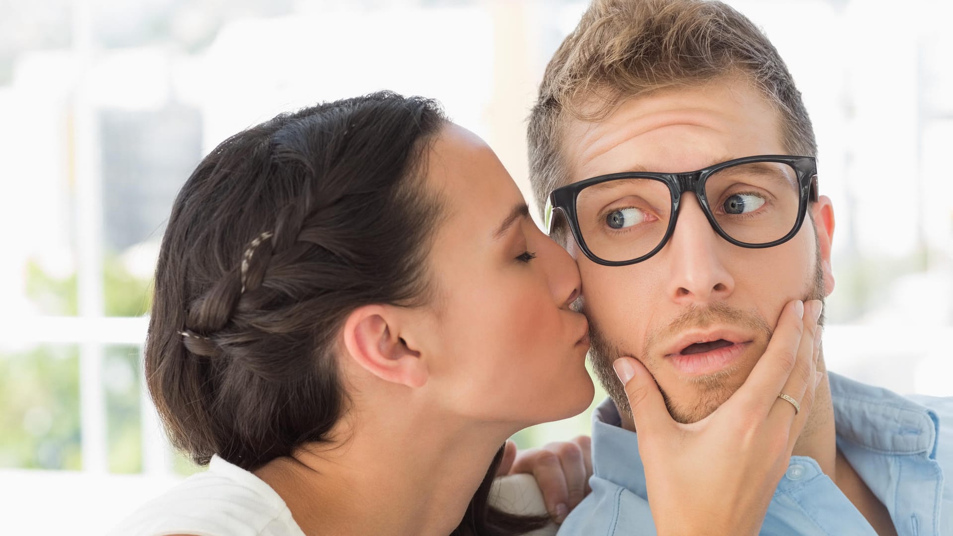 Eine junge Frau küsst einen jungen Mann