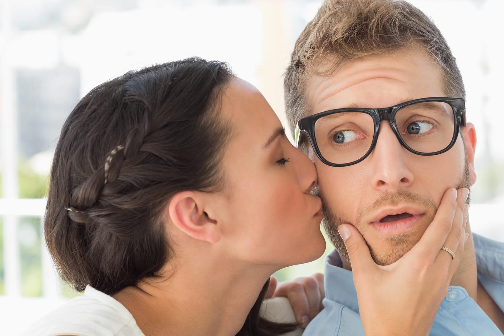 Eine junge Frau küsst einen jungen Mann