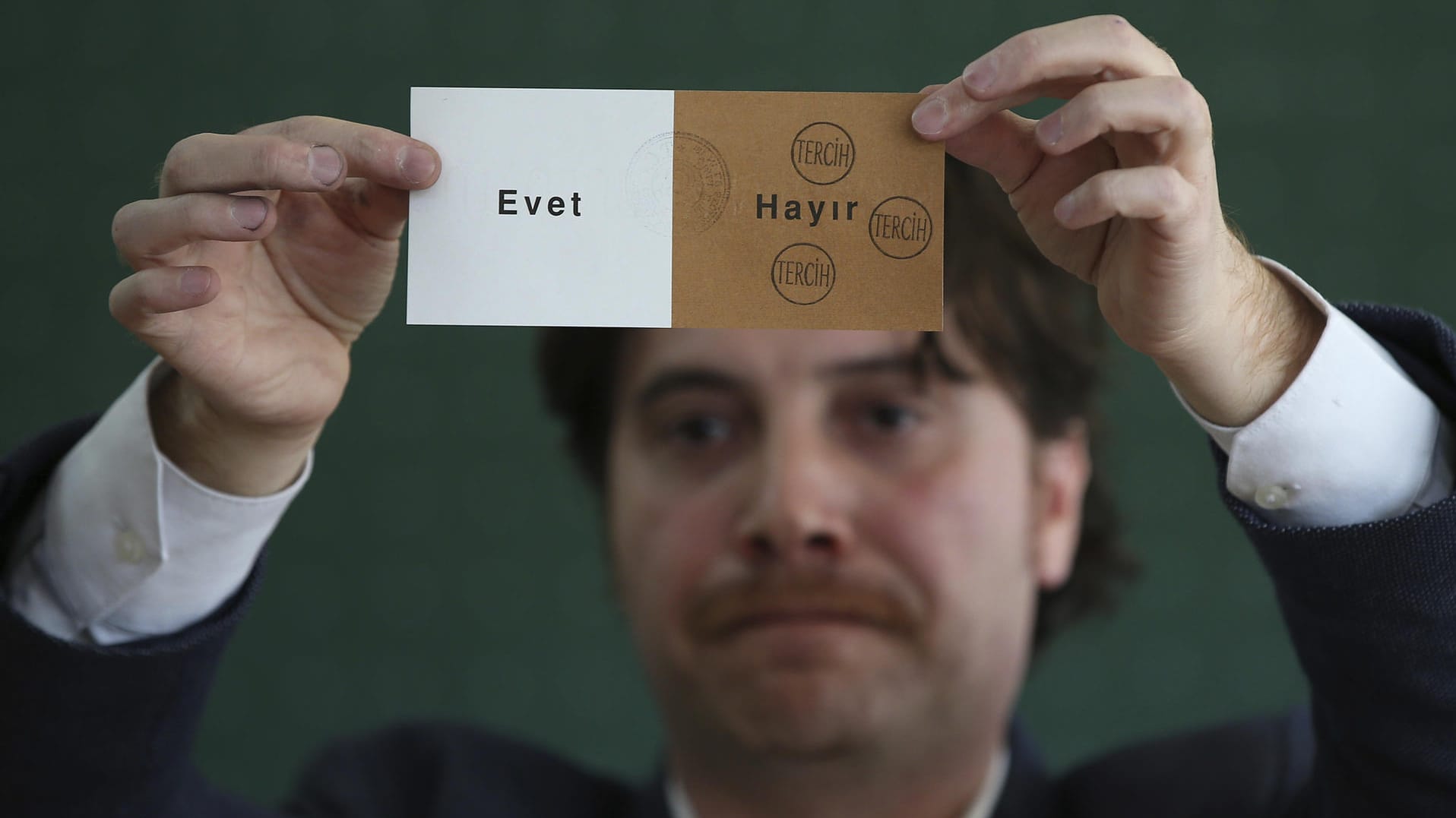 Ein Mitglied eines Wahlkomitees hält in einem geschlossenen Wahllokal bei der Auszählung einen abgestempelten Stimmzettel hoch. Ein Mitglied eines Wahlkomitees hält in einem geschlossenen Wahllokal bei der Auszählung einen abgestempelten Stimmzettel hoch.