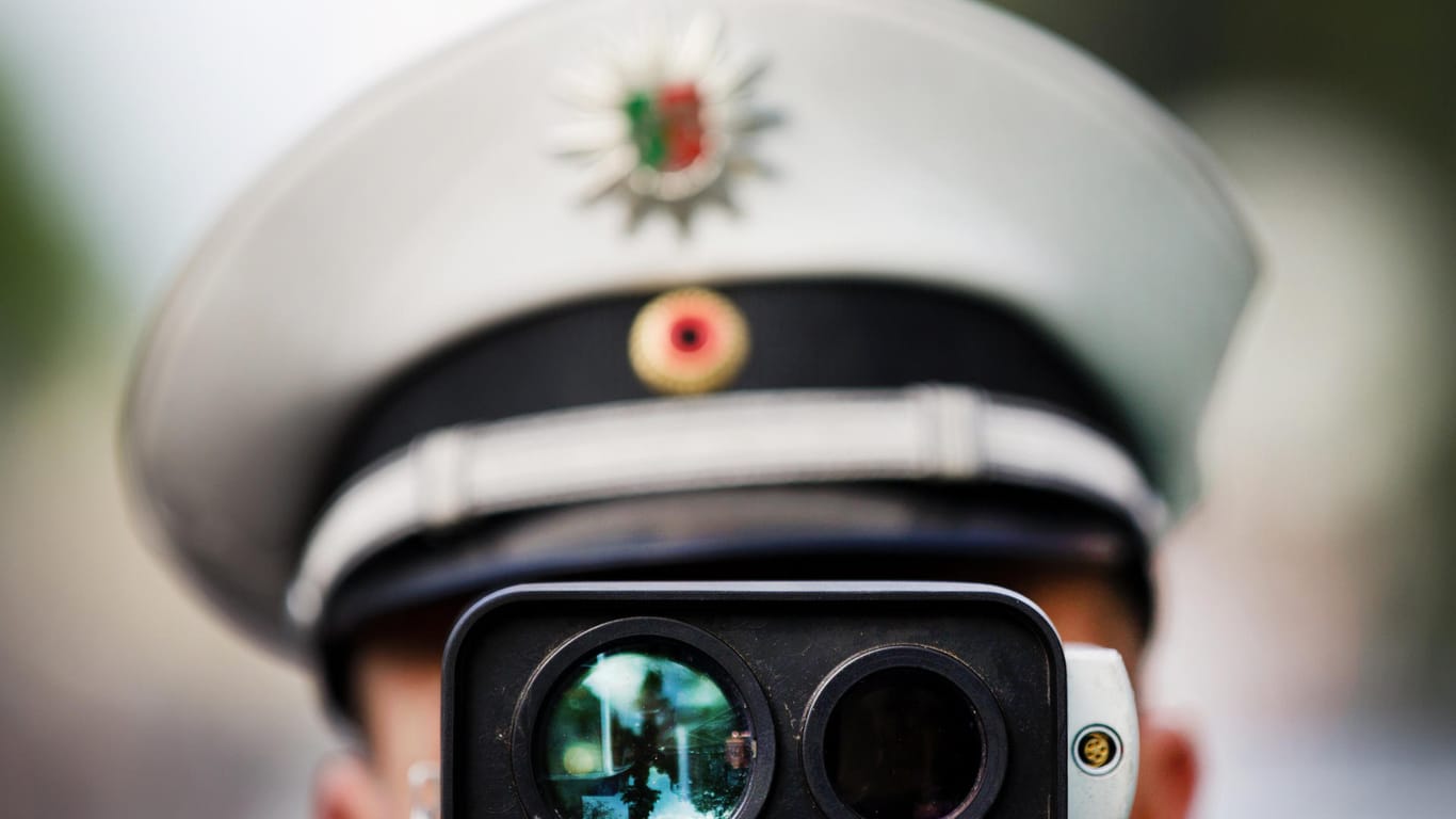 Ein Polizist schaut durch einen Laser-Geschwindigkeitsmesser.