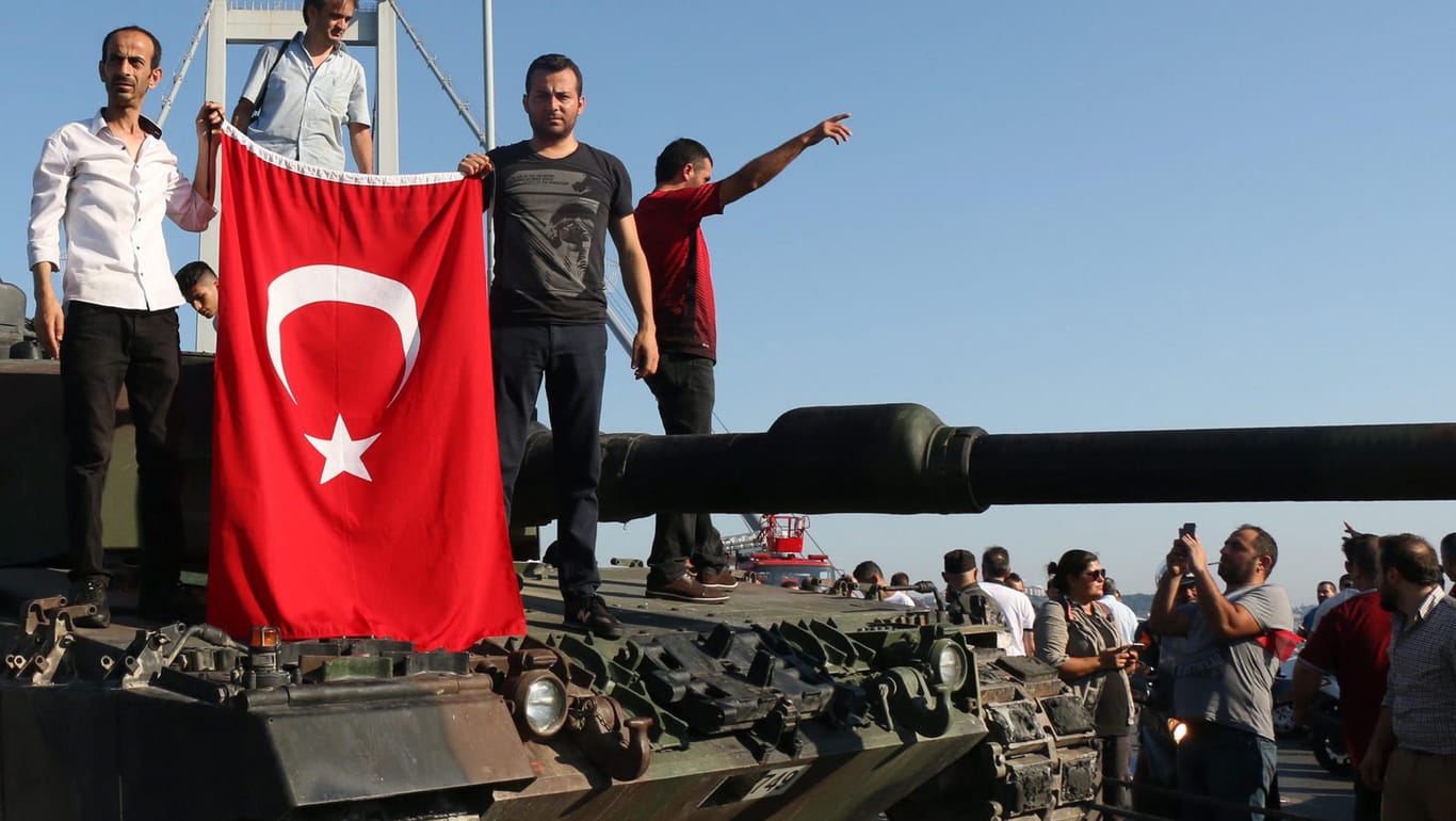 Türkische Polizisten und Anhänger von Präsident Erdogan stehen nach dem gescheiterten Putsch mit einer türkischen Flagge auf einem Panzer in Istanbul.