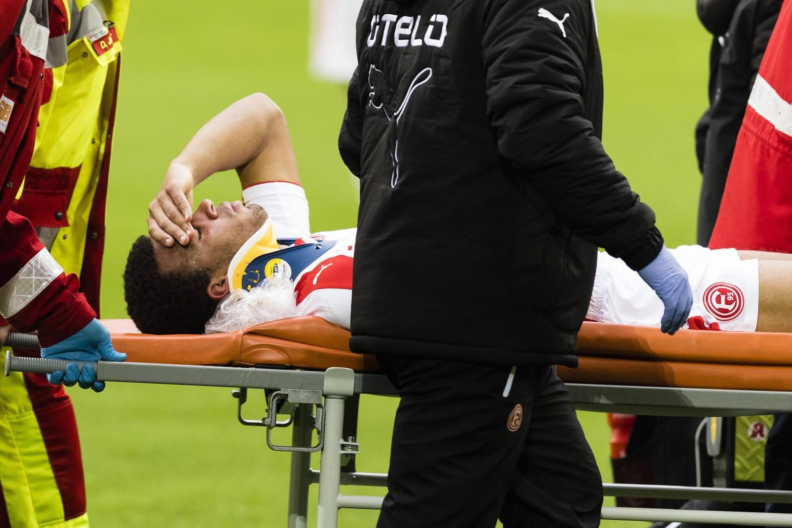 Kevin Akpoguma wird mit einer Halskrause von Rettungssanitätern vom Platz getragen.