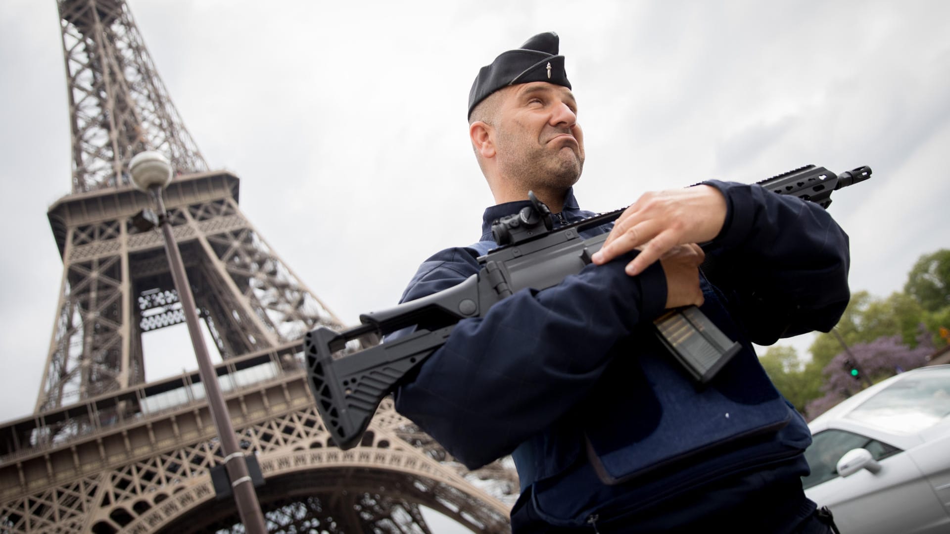 Ein schwer bewaffneter Polizist patroulliert am am Eiffelturm in Paris.