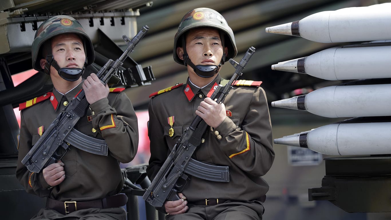 Zwei nordkoreanische Soldaten sitzen bei einer Militärparade am 15.04.2017 in Pjöngjang (Nordkorea) auf einem mobilen Raketenwerfer.