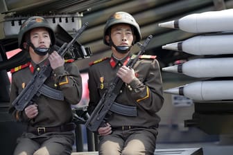 Zwei nordkoreanische Soldaten sitzen bei einer Militärparade am 15.04.2017 in Pjöngjang (Nordkorea) auf einem mobilen Raketenwerfer.