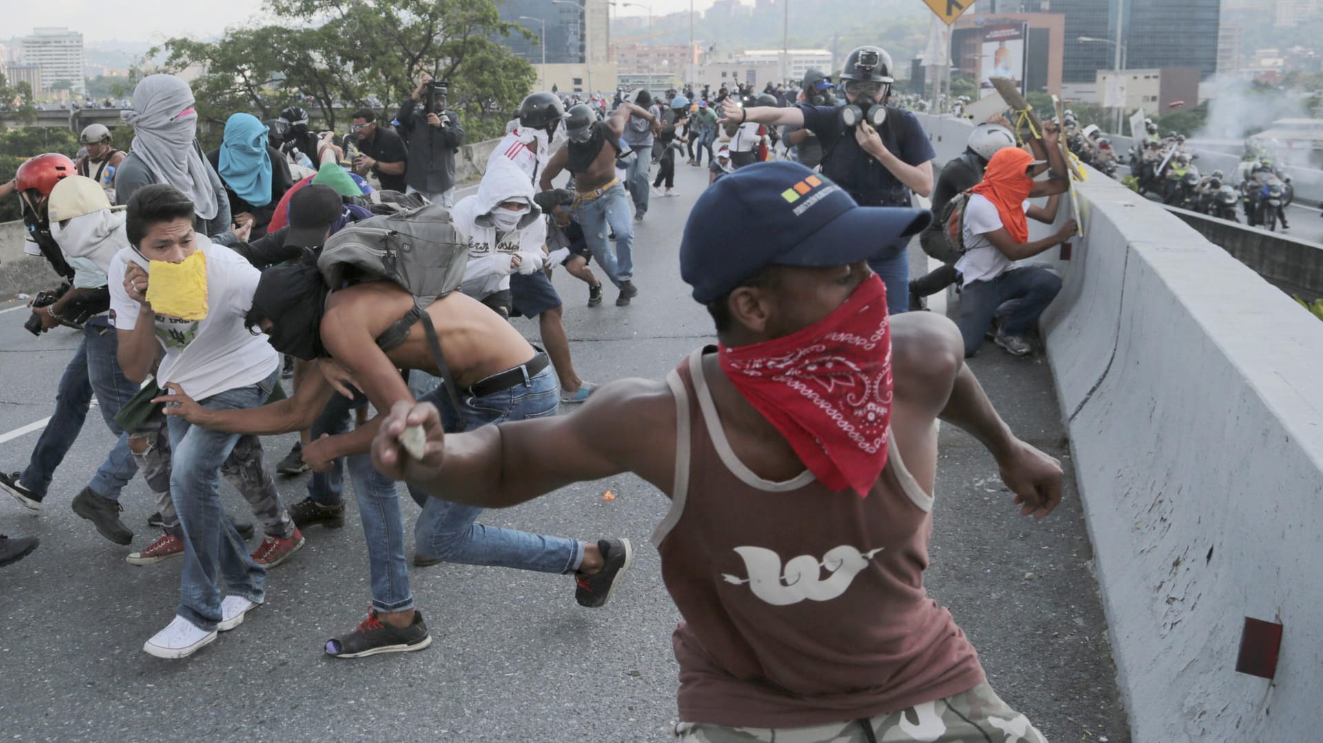 Demonstranten werfen in Caracas während eines Protests gegen Venezuelas Präsident Maduro Steine auf Polizisten. Demonstranten werfen in Caracas während eines Protests gegen Venezuelas Präsident Maduro Steine auf Polizisten.