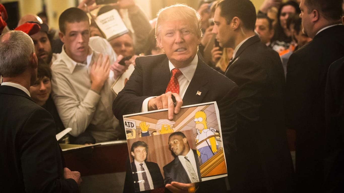 Bei einem Wahlkampfauftritt posiert Donald Trump mit einem Bild, dass ihn bei der Zeichentrickserie "Die Simpsons" zeigt.