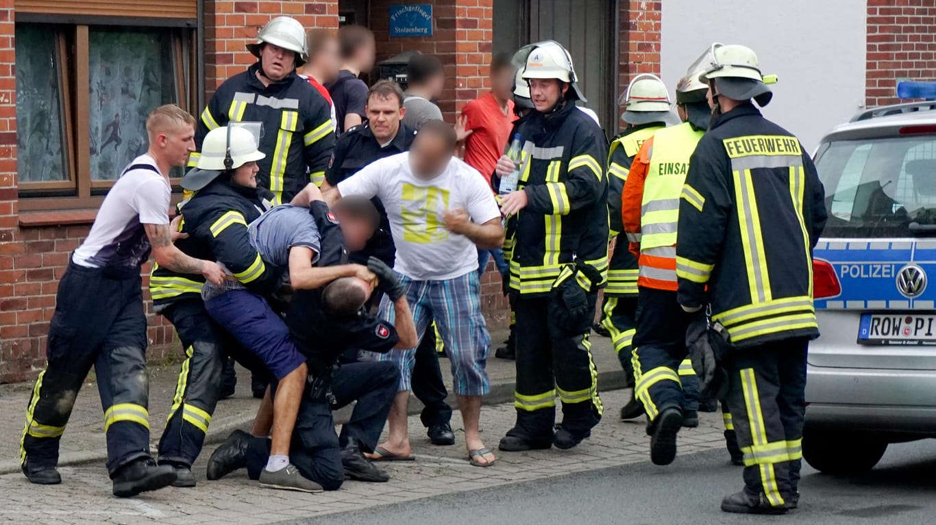 Drei Männer behindern am 05. Juli 2015 in Bremervörde (Niedersachsen) nach einem tödlichen Unfall die Arbeit der Rettungskräfte.