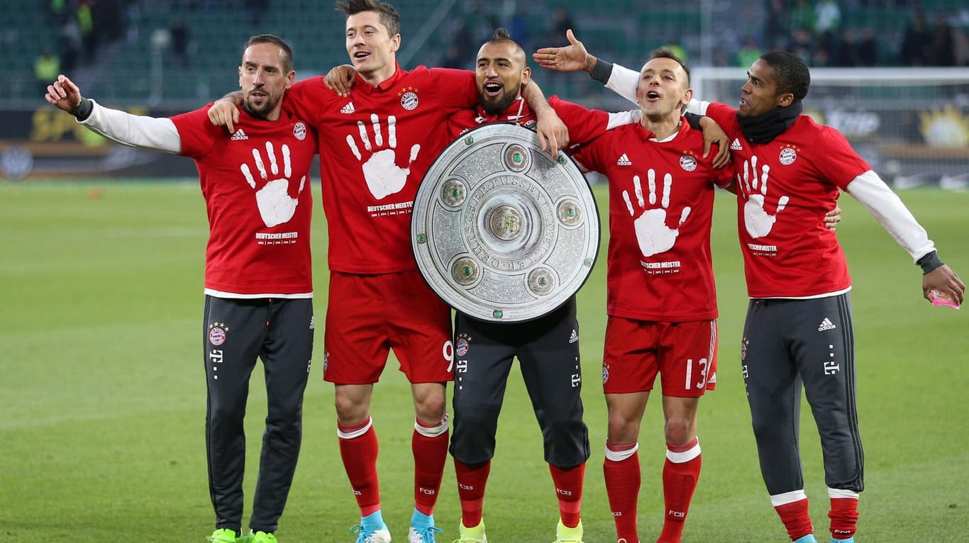 Die Spieler des FC Bayern feiern mit einer Meisterschale aus Pappe den fünften Titel in Serie.