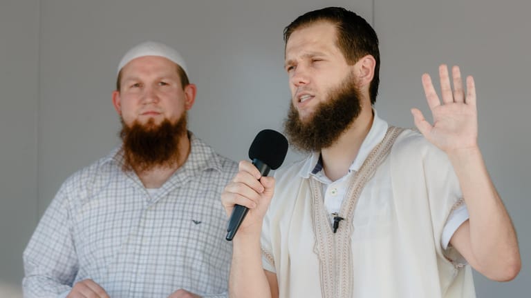 Die islamistischen Prediger Pierre Vogel (l-r) alias "Abu Hamza" und Sven Lau alias "Abu Adam" stehen während einer Kundgebung gemeinsam auf dem Lautsprecherwagen.