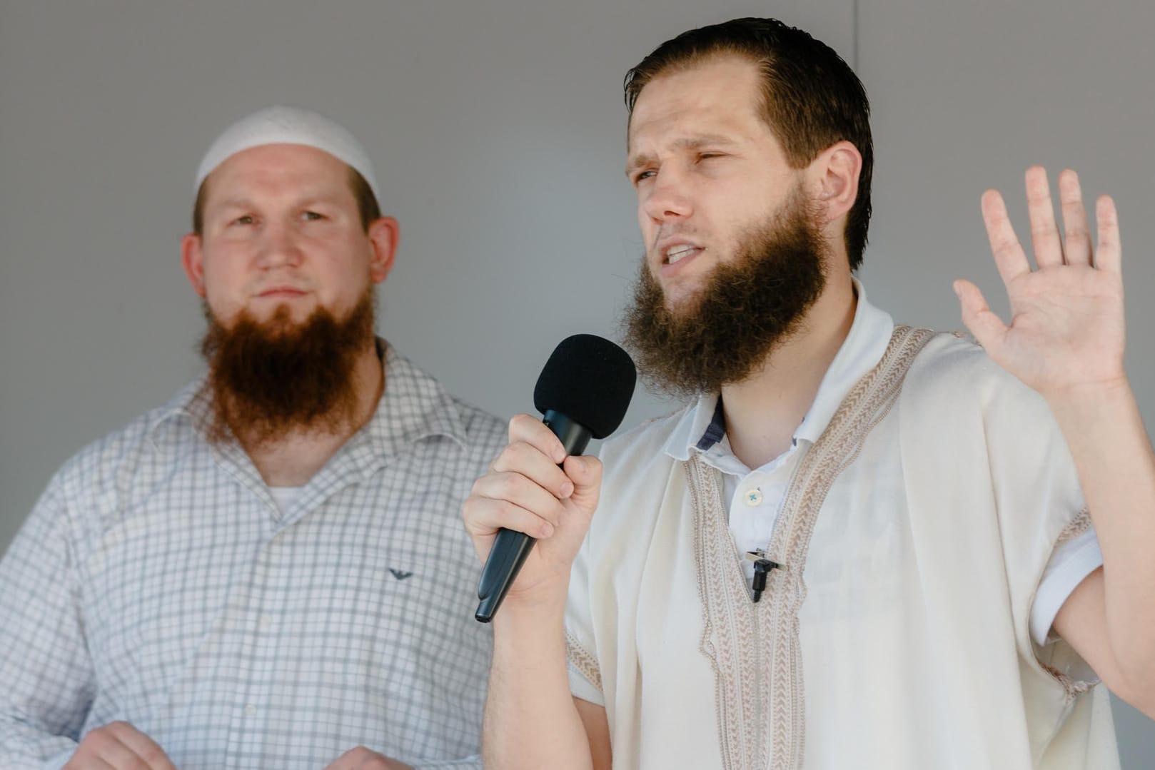 Die islamistischen Prediger Pierre Vogel (l-r) alias "Abu Hamza" und Sven Lau alias "Abu Adam" stehen während einer Kundgebung gemeinsam auf dem Lautsprecherwagen.