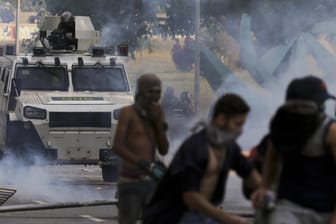 Demonstranten versuchen sich während eines Protests vor Tränengas zu schützen.