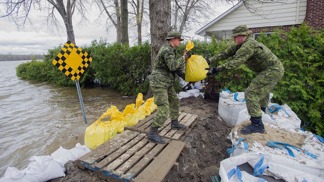 Kanadische Soldaten füllen Säcke mit dem Sand, um die Ufer an den Fußen zu stabilisieren.