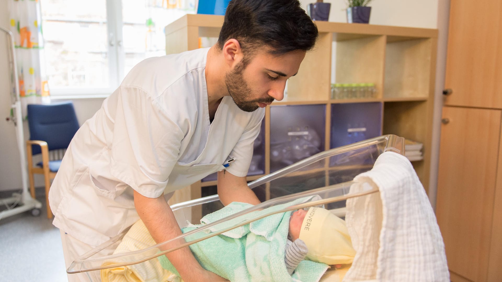 Entbindungshelfer Milco Messina legt ein Neugeborenes in ein Kinderbett.