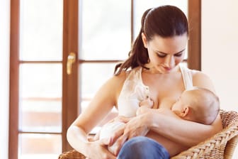 Eine Frau stillt ihr Baby.