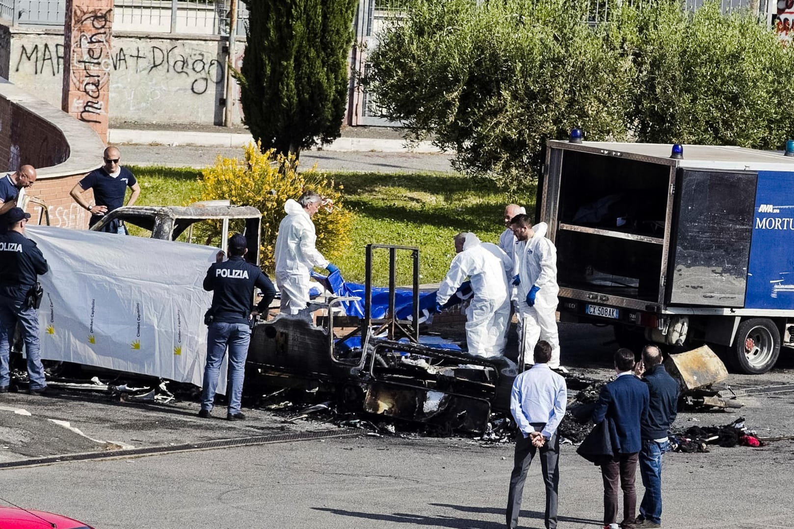 Forensiker der Polizei untersuchen die Überreste des ausgebrannten Wohnwagens in Rom.