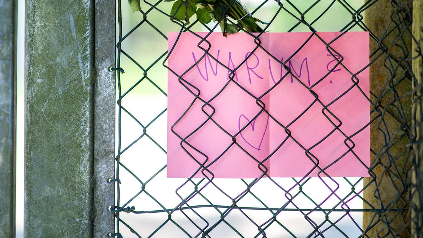 Ein Zettel mit der Aufschrift "Warum?" hängt in einem Zaun nahe des Fundorts einer Babyleiche an einer Abwasserpumpstation.