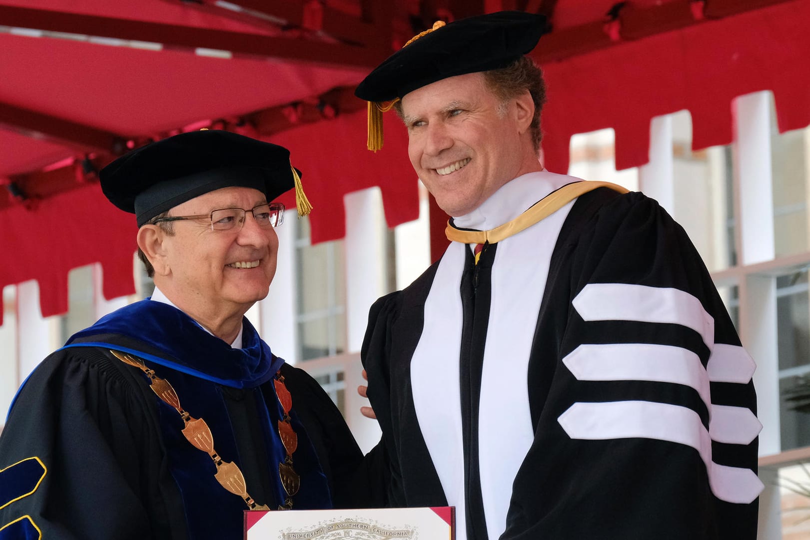 Der Präsident der University of Southern California C.L.Max Nikias (links) überreicht dem sichtlich erfreuten Will Ferrel (rechts) den Ehrendoktortitel seiner Alma Mater.