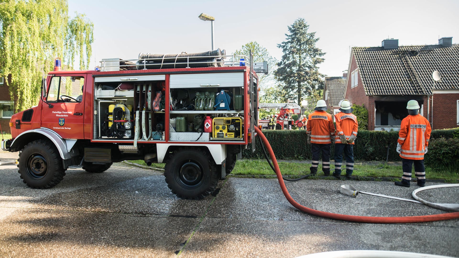 Feuerwehrleute stehen in Klostermoor an einem Haus, das durch eine Gasexplosion beschädigt wurde.