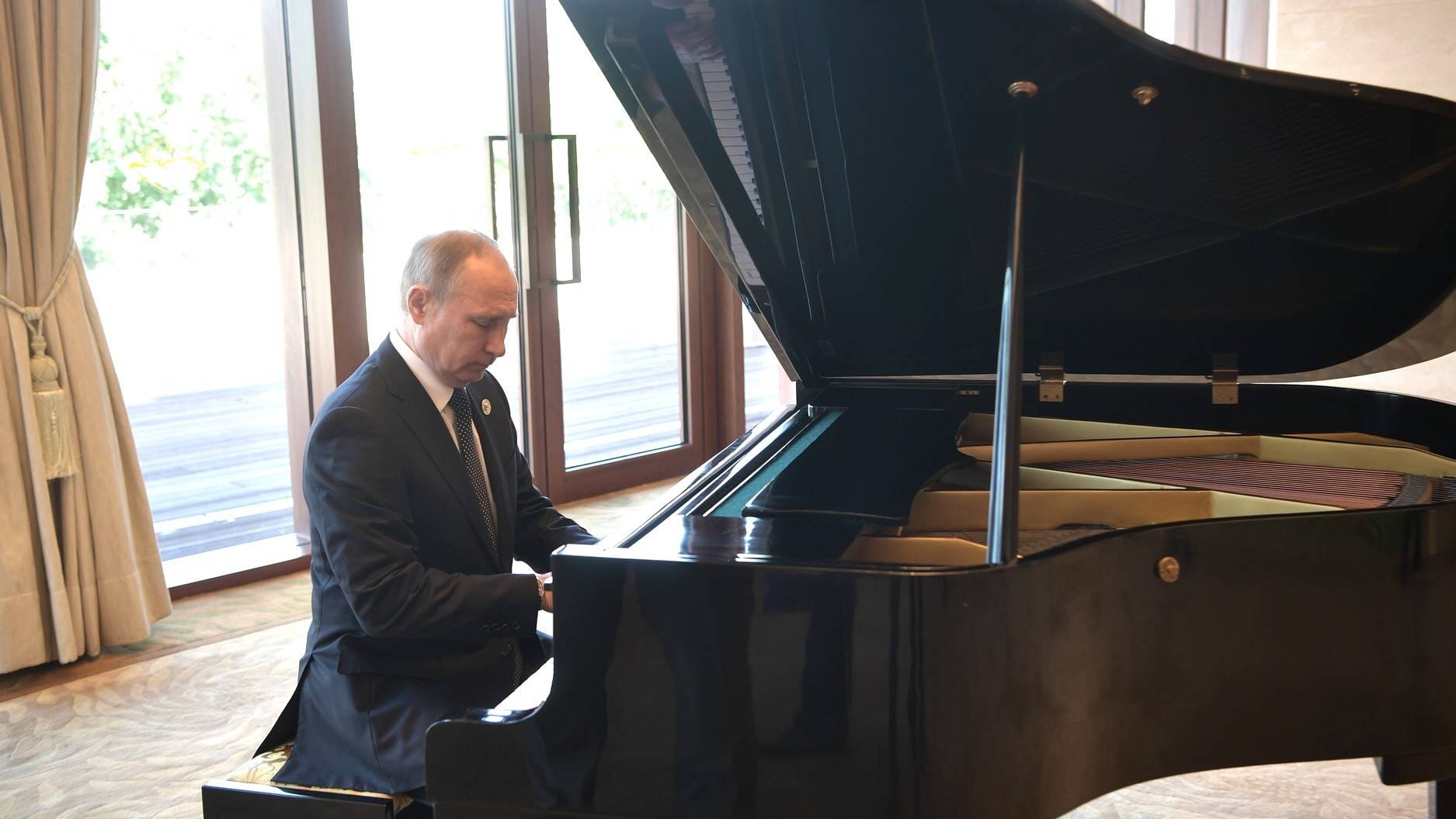 Der russische Präsident Wladimir Putin sitzt vor einem Treffen mit Chinas Staatschef Xi Jinping am Klavier. Der russische Präsident Wladimir Putin sitzt vor einem Treffen mit Chinas Staatschef Xi Jinping am Klavier.