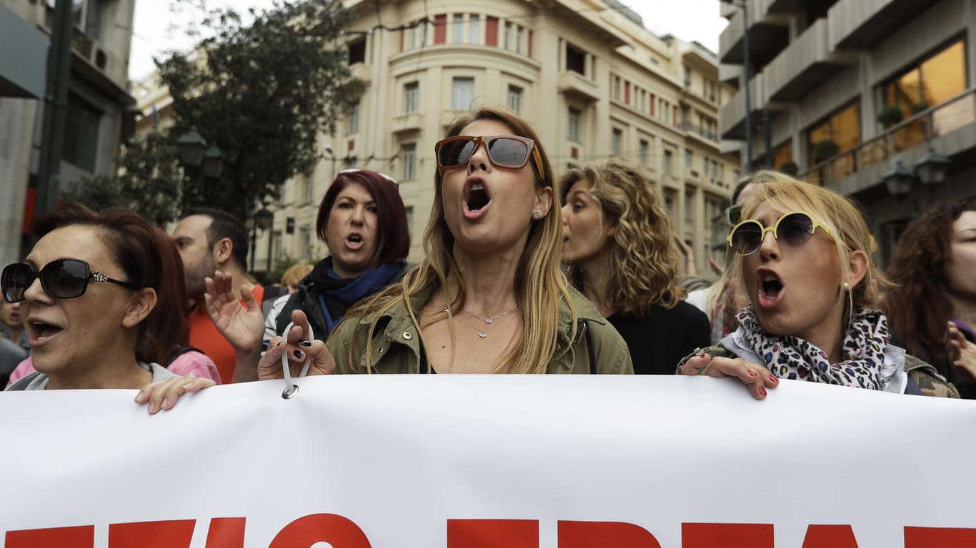 Demonstranten beteiligen sich am Generalstreik und ziehen mit einem Transparent durch die Innenstadt von Athen (Griechenland).