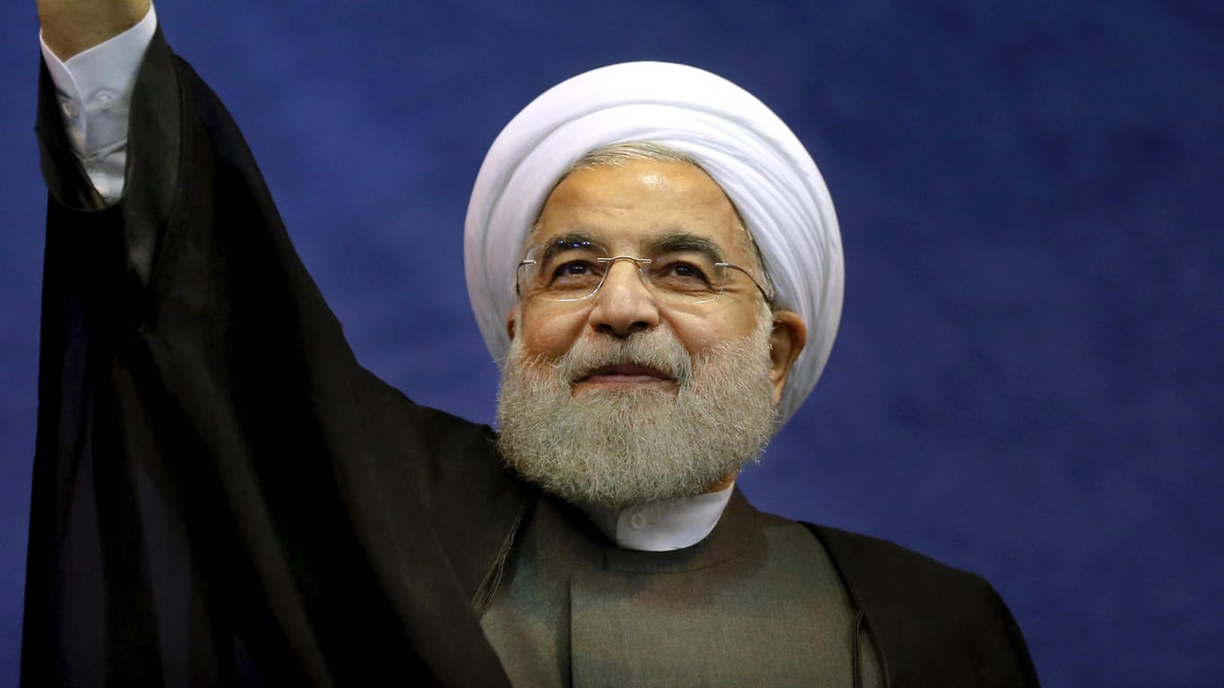 Der iranische Präsident Hassan Ruhani winkt seinen Anhängern bei einer Wahlkampfveranstaltung zu.