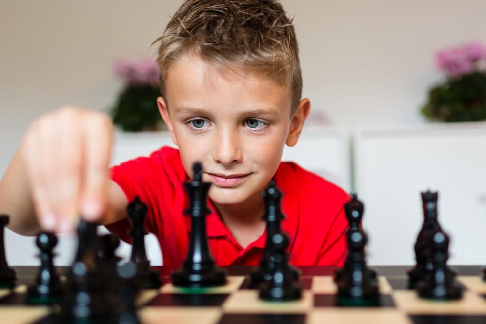 Ein Junge spielt Schach.