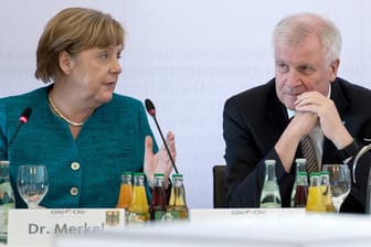 Bundeskanzlerin Angela Merkel und der bayerische Ministerpräsident Horst Seehofer sitzen während der Fraktionsvorsitzendenkonferenz von CDU und CSU beisammen.