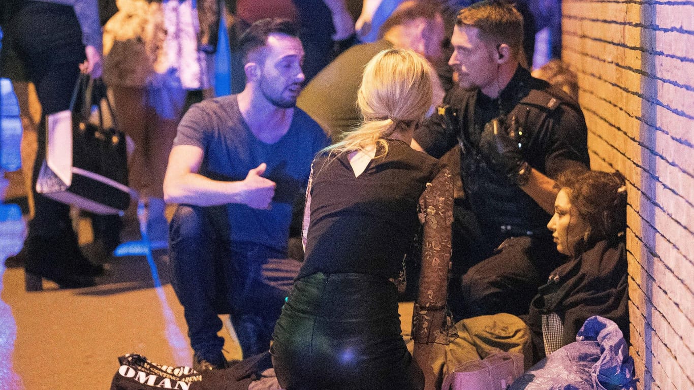 Polizisten helfen nach dem Anschlag in Manchester einer Verletzten.
