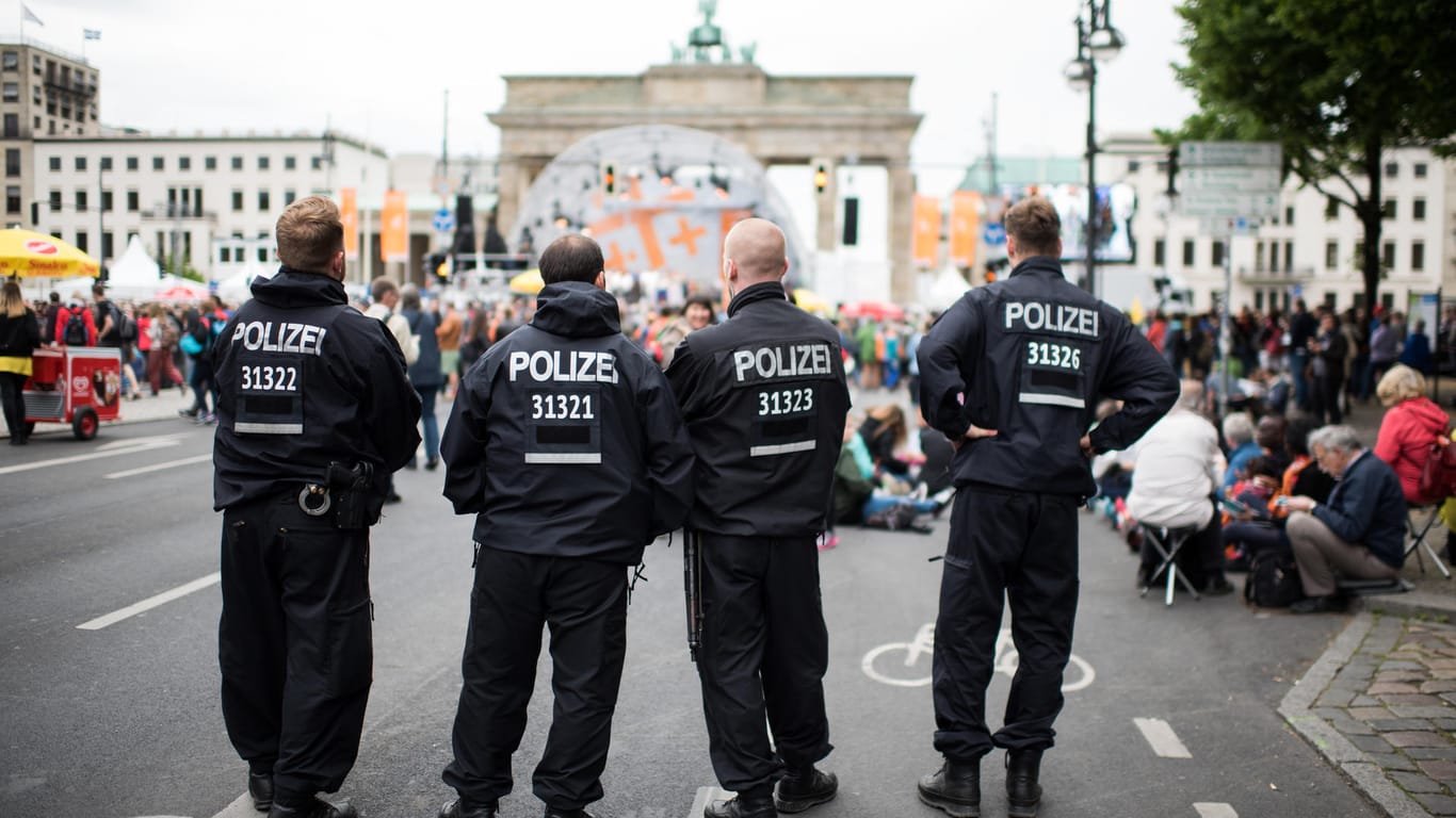 Polizeibeamte stehen vor einem der Eröffnungsgottesdienste am Brandenburger Tor in Berlin.